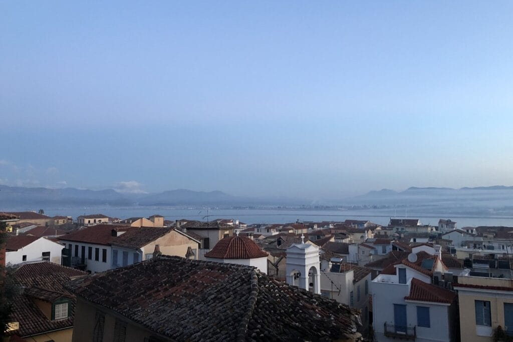 Rooftops in Nafplio at dawn, with the bay and the mountains behind