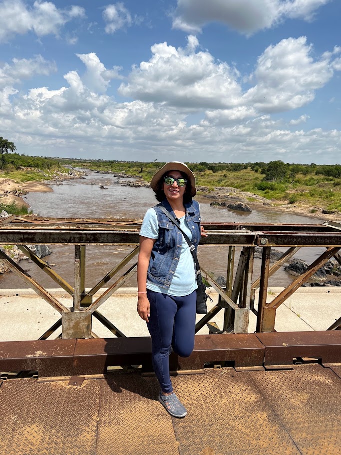 Milli Gupta standing on a bridge over the Mara River in Kenya's Maasai Mara