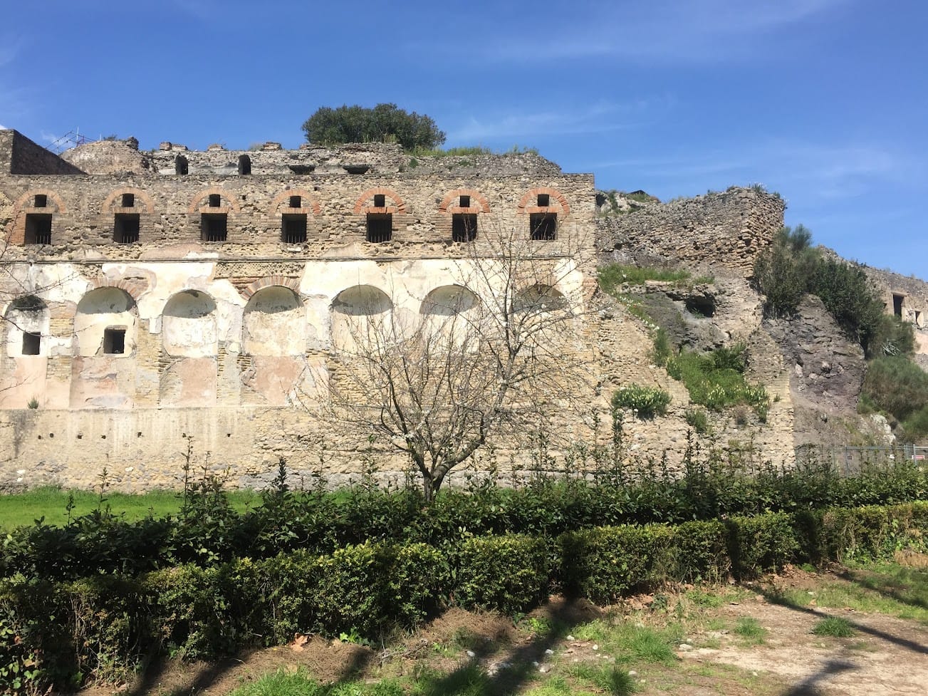 The ancient city walls and terraces of Pompeii under a clear blue sky