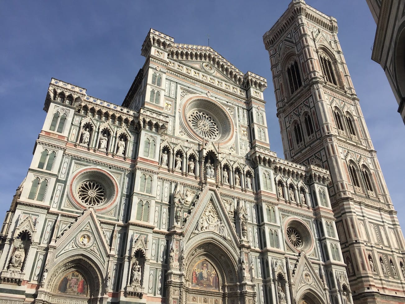 The marble façade and campanile of Florence Cathedral seen from below in afternoon light
