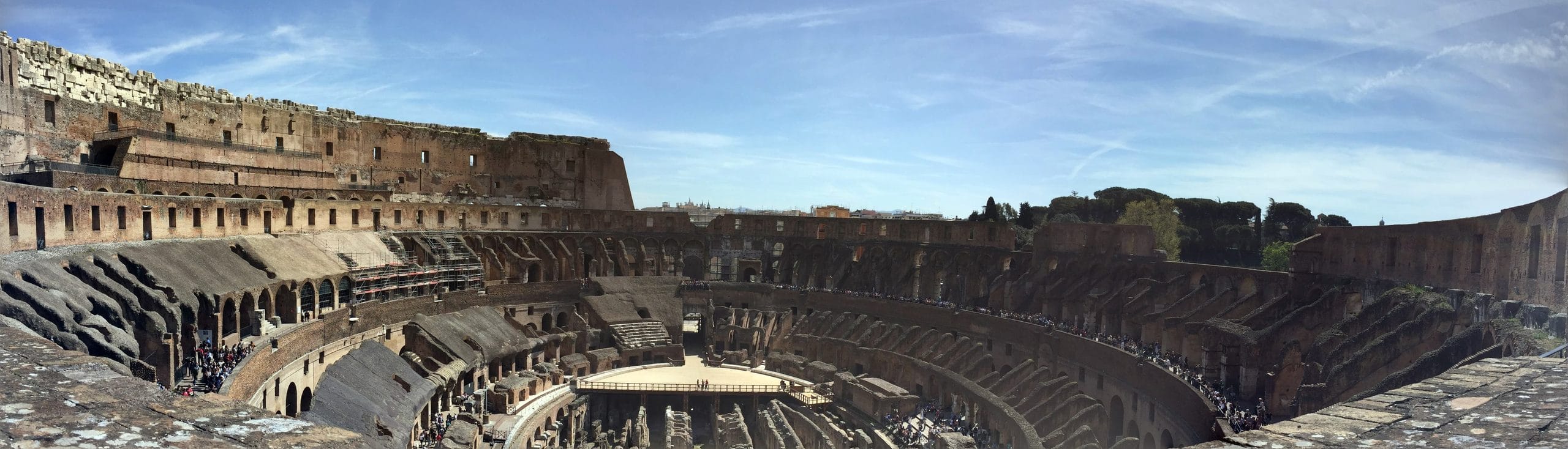 Panorama of the Colosseum interior showing the full oval of tiers and the exposed hypogeum