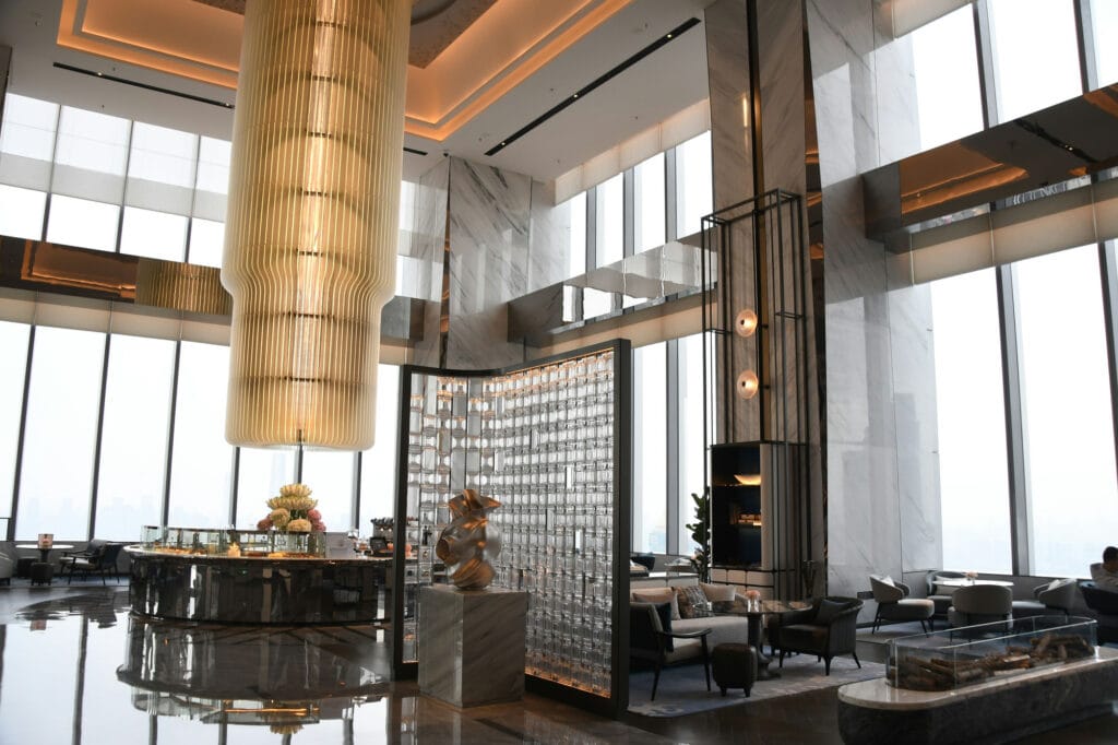 Grand hotel lounge with marble columns and floor-to-ceiling city views