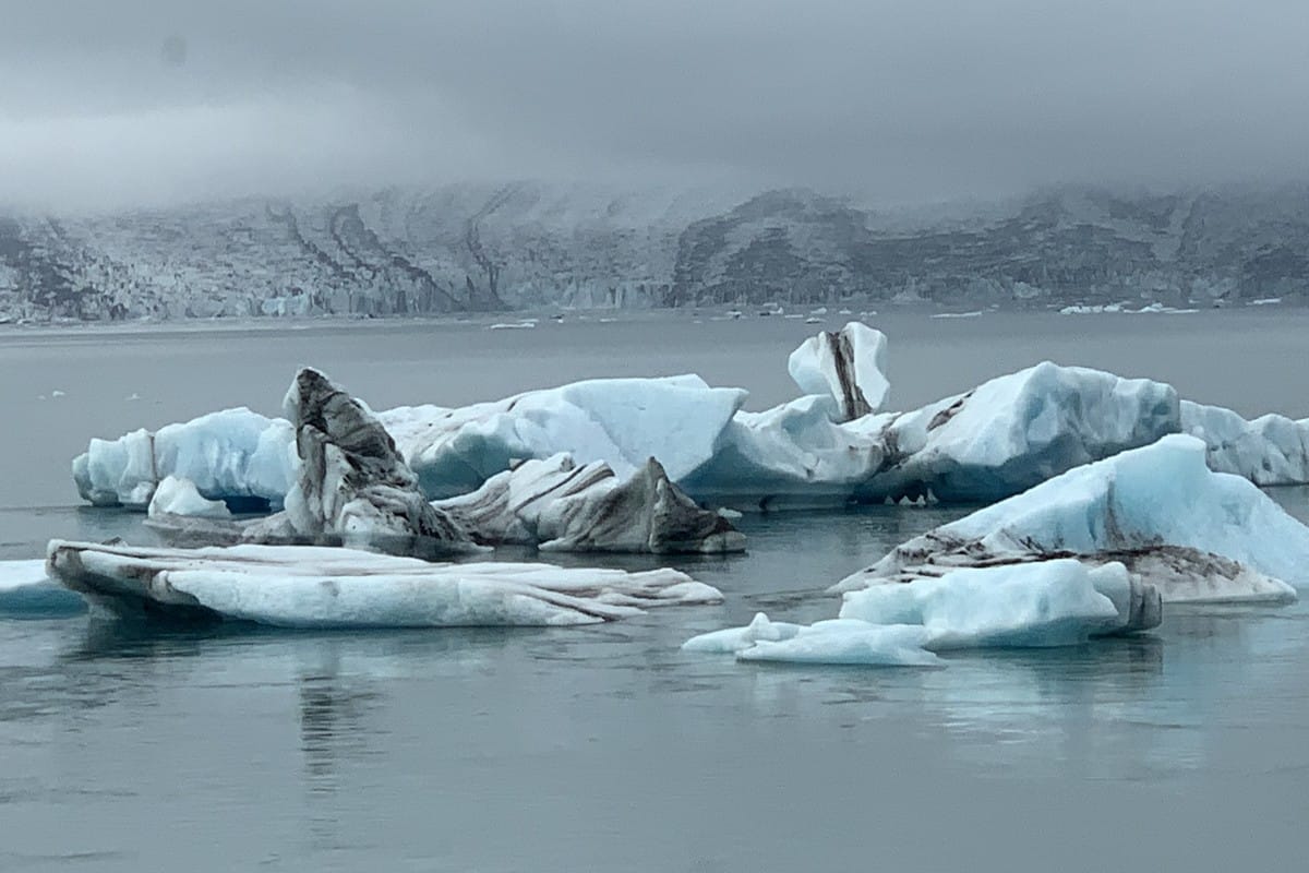 Icebergs grounded on the shore of Jökulsárlón lagoon with the glacier behind on Iceland's south coast