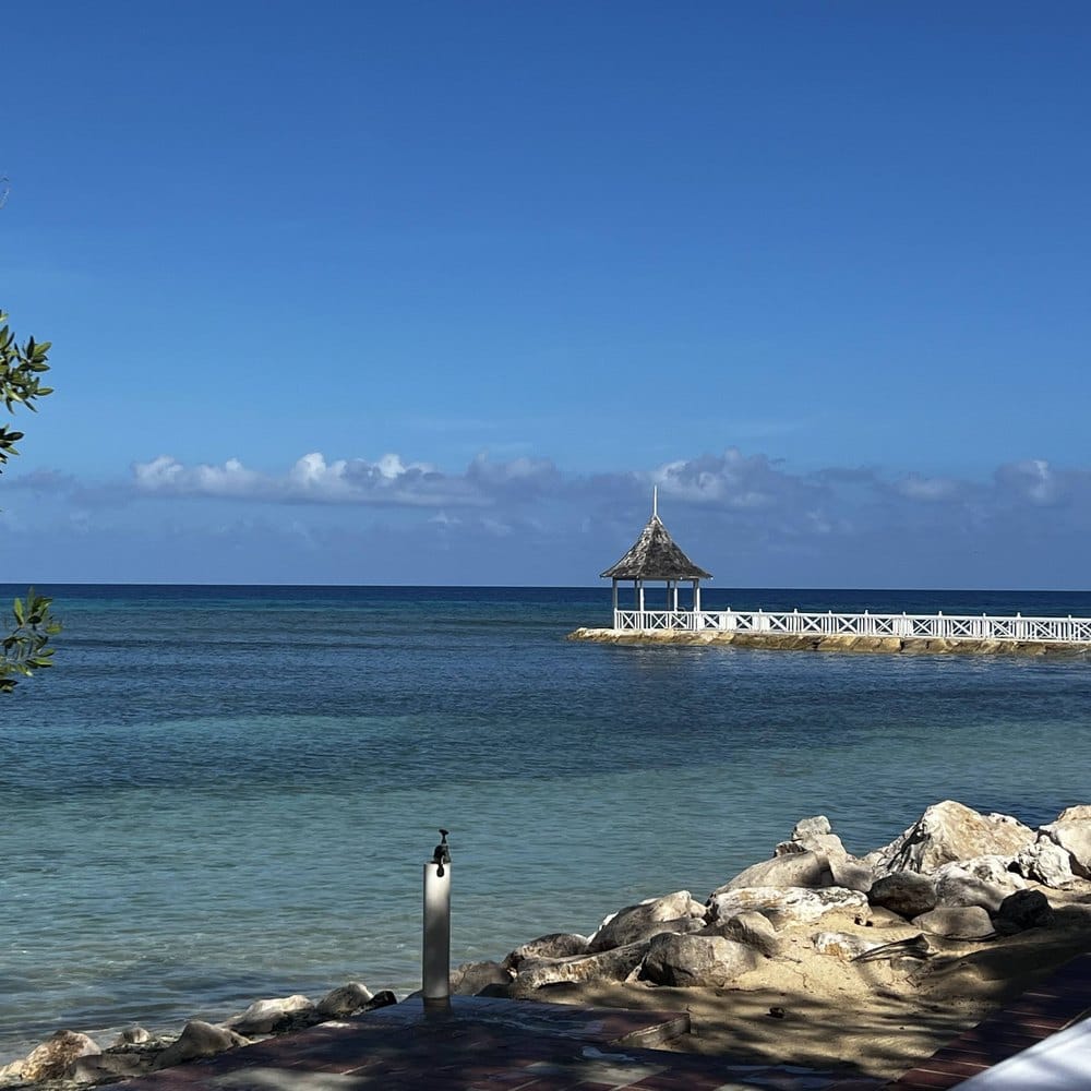 Seaside gazebo under blue midday sky, Jamaica