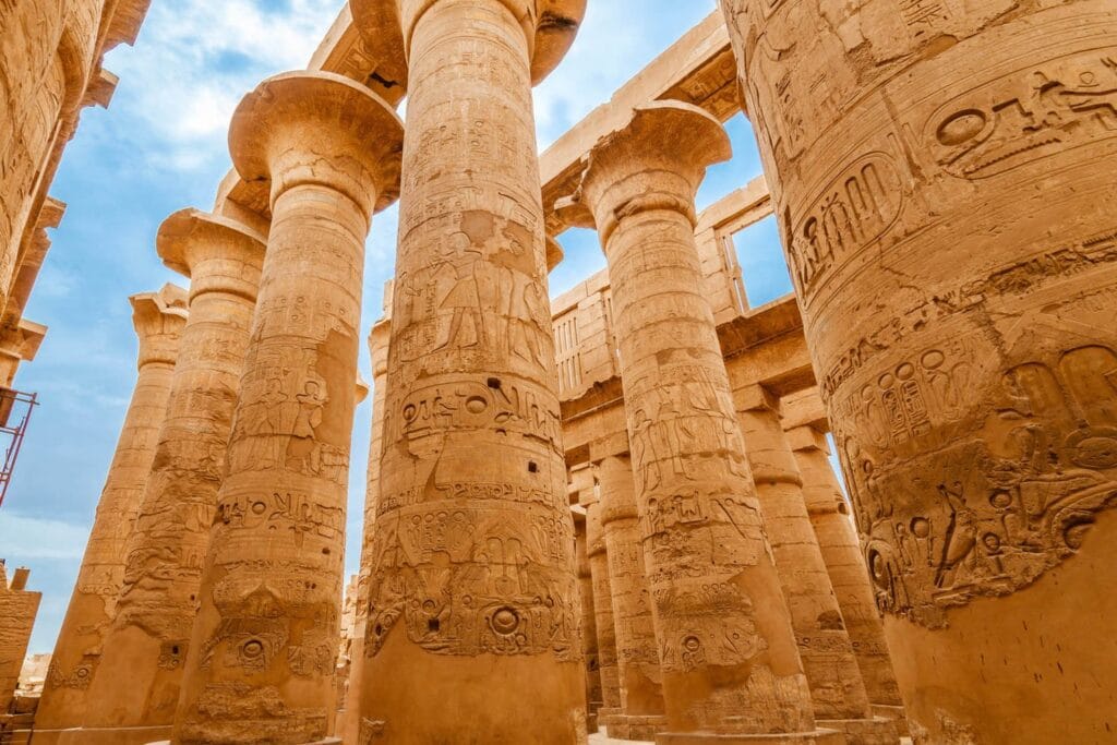 Towering carved sandstone columns in the hypostyle hall of Karnak Temple, Luxor