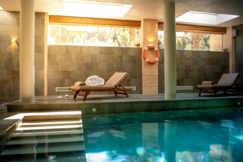 Quiet indoor spa pool with a lounger in warm afternoon light