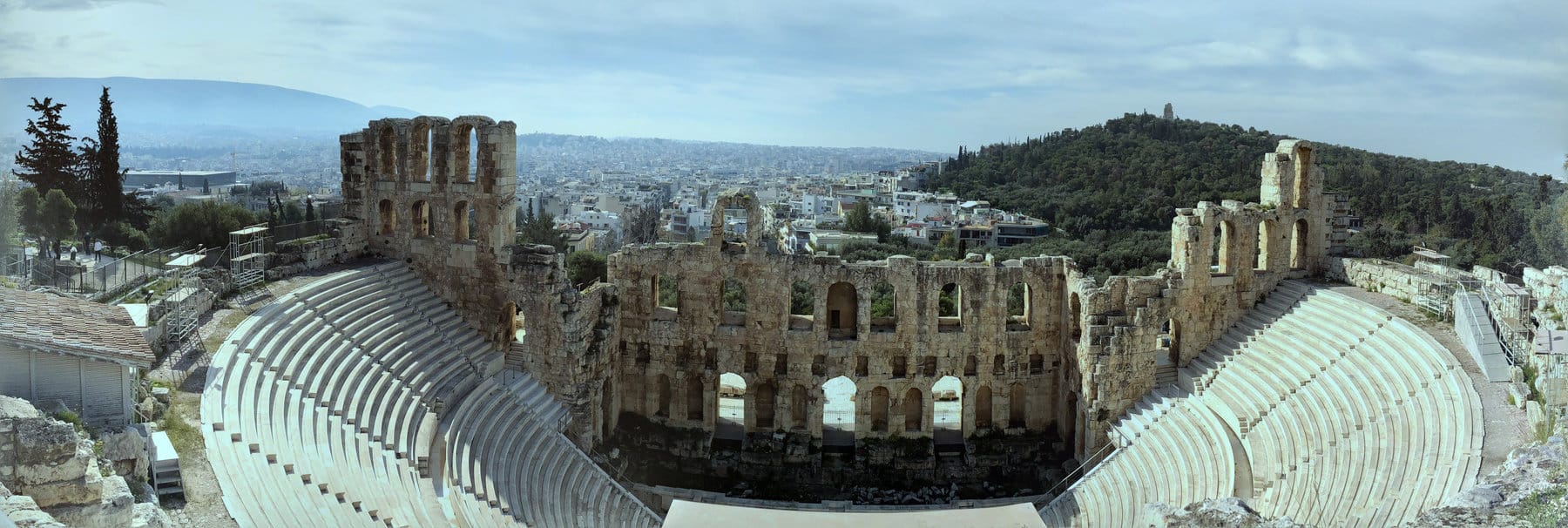The Odeon of Herodes Atticus, a Roman theater on the south slope of the Acropolis, with the city of Athens and Philopappos Hill beyond.