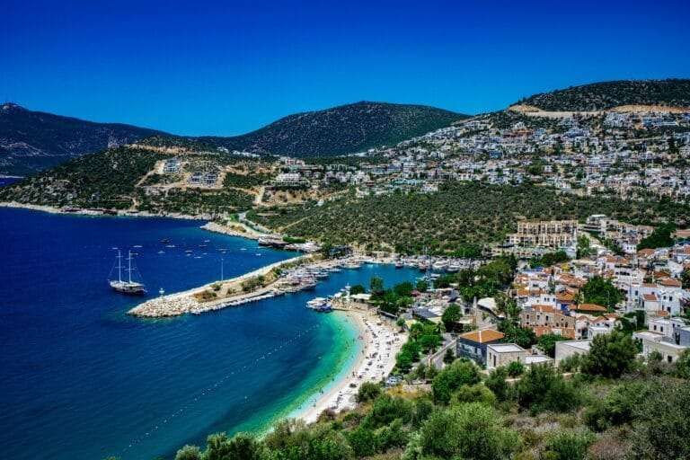 A harbor town with sailing boats and a turquoise bay on Turkey's Mediterranean coast